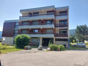 a large building with a car parked in front of it at Appartement à Autrans, 39m², 6 pers, proche pistes et village, balcon est, parking privé - FR-1-737-42 in Autrans