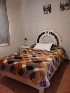 a bedroom with a bed with a checkered blanket at QUINTA SAN LUCAS TLAXCALA 