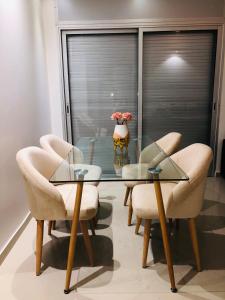 uma sala de jantar com uma mesa de vidro e cadeiras em Luxury Appartment in Hassan tour em Rabat