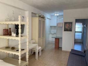 Una sala de estar con una mesa y una cocina. en Studio Almenara Beach, en Barrio-Mar