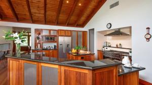 una cucina con armadi in legno e piano di lavoro nero di Reign Manor and Coach House a Worragee
