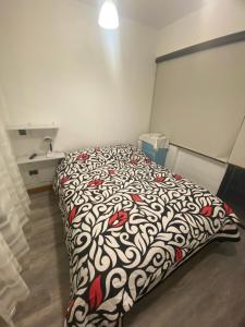 Bett in einem Zimmer mit einer schwarzen und weißen Decke in der Unterkunft Aribibi Monoambiente in La Paz