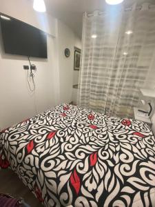 Schlafzimmer mit einem Bett mit einer schwarzen und weißen Bettdecke in der Unterkunft Aribibi Monoambiente in La Paz