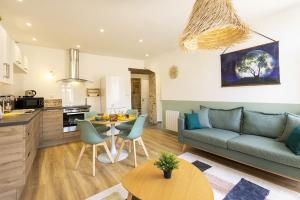 sala de estar con sofá y mesa en L'Emeraude - 1 à 4P - Wifi Fibre - Parking Gratuit, en Pont-d'Ain