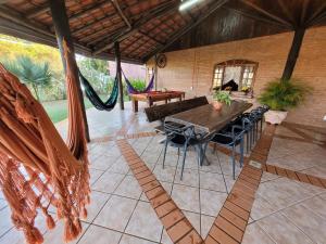 a living room with a table and chairs and a couch at Chácara Kioski - Suítes e Cabanas in Brotas