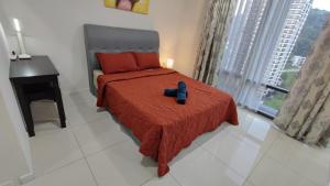 Cette chambre comprend un lit avec une couverture rouge et un bureau. dans l'établissement FHAZ KLE- 2bdroom at KL East Mall ! Gombak, à Kuala Lumpur