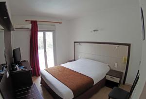 a bedroom with a large bed and a large window at Le Méditerranée in Porto Ota