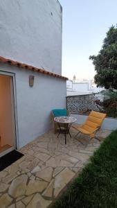 a patio with two chairs and a table next to a building at Casa James in Vejer de la Frontera