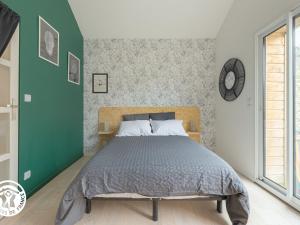 1 dormitorio con cama y pared verde en Gîte Mareuil-sur-Lay-Dissais, 3 pièces, 5 personnes - FR-1-426-537, en Mareuil-sur-Lay