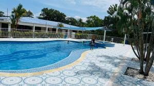 una mujer parada frente a una piscina en HOTEL EL RUBY, en San Martín