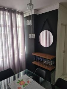 a dining room with a glass table and a mirror at Cobertura Duplex com Piscina Exclusiva na Pituba! in Salvador