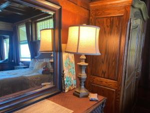 una lámpara sentada en una mesa junto a un espejo en Hilo Bay Oceanfront Bed and Breakfast en Hilo