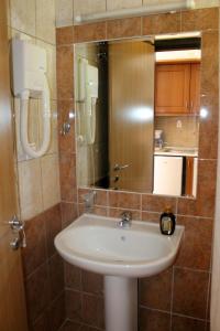 a bathroom with a sink and a mirror at Lido Sofia Apartments in Agios Gordios