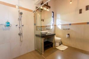 een badkamer met een douche, een wastafel en een toilet bij La Maima in Dapa