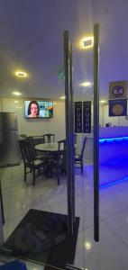 a dining room with a table and chairs and a television at The 8 Capsule Hotel Bukit Bintang in Kuala Lumpur