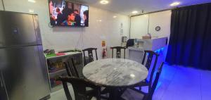 a kitchen with a table and chairs and a refrigerator at The 8 Capsule Hotel Bukit Bintang in Kuala Lumpur