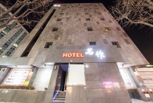 HOTEL MYEONG JAK في سوون: مبنى فندق امامه لافته للفندق