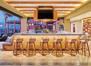 a bar in a hotel with stools and a television at Timbers Kaua'i in Lihue