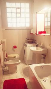 a white bathroom with a toilet and a sink at Residenza Esse in Angera