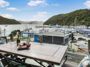 uma mesa com uma garrafa de vinho em cima de uma marina em Oxley's Waterfront Apartment em Picton