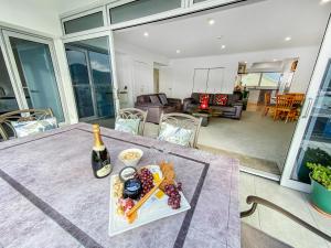 uma mesa com um prato de comida e uma garrafa de vinho em Oxley's Waterfront Apartment em Picton