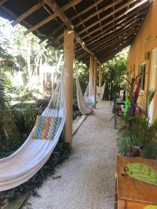 a couple of hammocks hanging from a building at Casa Tzalam Tulum selva in Tulum