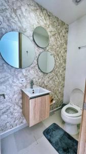 y baño con lavabo, aseo y espejos. en Cartagena Seaview Elegance, en Cartagena de Indias
