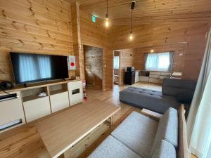 a living room with a couch and a flat screen tv at Hatagoya Jozankei Shoten-Adult Only in Sapporo