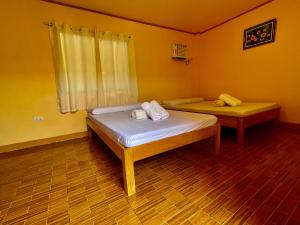 um quarto com 2 camas num quarto com paredes amarelas em GOLDEN SUNSET INN em Siquijor