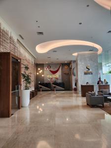 a lobby with a waiting area with couches and avertisement at Citadines Gatot Subroto Jakarta in Jakarta