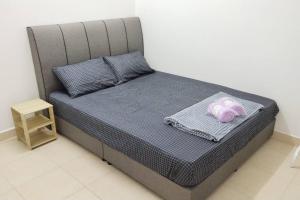 uma cama com uma toalha roxa em cima em 1181 GCH S2 # U Homestay em Seremban