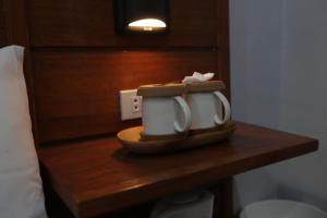 zwei Kaffeetassen auf einem Tisch in einem Hotelzimmer in der Unterkunft Cerca Hotel in Boracay