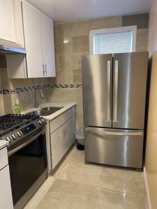 a kitchen with a stainless steel refrigerator and a sink at Hoover in Kew Gardens