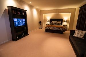 een slaapkamer met een bed en een televisie. bij Large luxury apartment located right in town in Taupo