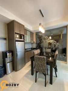Il comprend une cuisine équipée d'une table, de chaises et d'un réfrigérateur. dans l'établissement Thamrin City Serviced Apartment Full Facilities B2CT1, à Jakarta