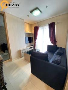 - un salon avec un canapé et une fenêtre dans l'établissement Thamrin City Serviced Apartment Full Facilities B2CT1, à Jakarta