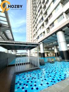 un bâtiment avec une piscine en face d'un bâtiment dans l'établissement Thamrin City Serviced Apartment Full Facilities B2CT1, à Jakarta