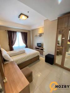 Cette chambre comprend un lit et un bureau. dans l'établissement Thamrin City Serviced Apartment Full Facilities B2CT1, à Jakarta