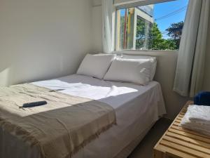 Dormitorio pequeño con cama y ventana en Apt 17 com 2 suítes com ar cond en Montes Claros