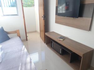 sala de estar con TV y sofá en Apt 17 com 2 suítes com ar cond en Montes Claros