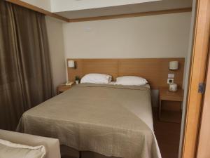 a bedroom with a large bed and a chair at La Bella Cintra, 672 in Sao Paulo
