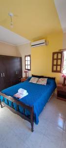 1 dormitorio con 1 cama grande con manta azul en Ayres de Catamarca en San Fernando del Valle de Catamarca