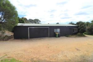 un edificio nero con un grande garage di Cedric Cottage a Mallacoota