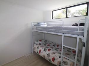 una camera da letto con due letti a castello e una finestra di Cedric Cottage a Mallacoota