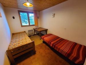 1 dormitorio con 2 camas, mesa y ventana en Chalet Les Carroz d'Arâches, 5 pièces, 8 personnes - FR-1-572-286, en Arâches-la-Frasse