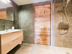 a bathroom with a shower and a wooden door at Appartement de Luxe Neuf avec Terrasse au Cœur des Gets, Proche des Pistes et Commerces - FR-1-598-153 in Les Gets +8 photos
