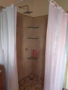 a shower with a white shower curtain in a bathroom at Preciosa cabaña rústica 
