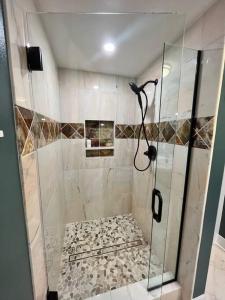 a shower with a glass door in a bathroom at Serene Oasis Getaway with Sauna and a swim spa. in Portland