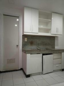 a kitchen with white cabinets and a sink and a door at WJV INN BASAK MANDAUE BRANCH in Mandaue City