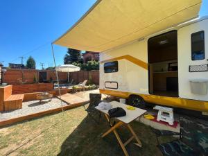 a camper parked in a yard with a table at Premium Caravan in Sapanca